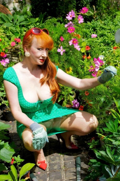 Busty redhead fingers her pussy while masturbating in a garden 11736677